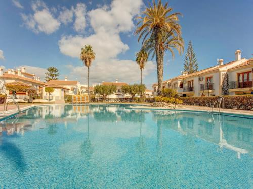 Una gran piscina con palmeras y casas. en Retreat Near Vera Beaches, en Los Amarguillos