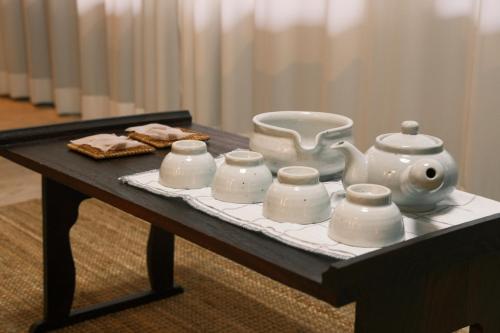 a table with a tea set on a table at Licensed Private hanok with Courtyard for 7, 10 min to metro in Busan