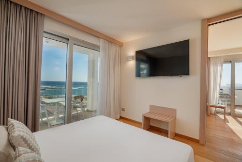 a hotel room with a bed and a television at Hotel Calabona in Alghero