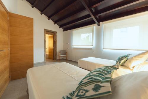 a bedroom with two beds and a window at Reverence Villas Avieira in Carballal