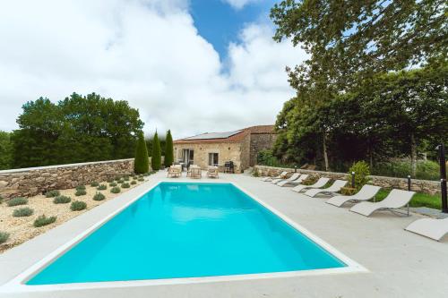 a swimming pool in a garden with chairs and a building at Reverence Villas Avieira in Carballal