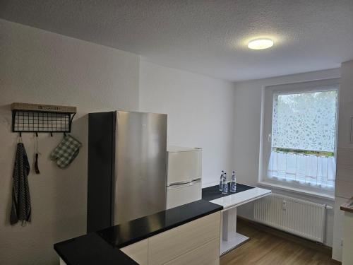 a kitchen with a stainless steel refrigerator and a window at Monteurs- & Gästewohnungen nähe Raffinerie Leuna & Geiseltalsee für 4Personen in Frankleben