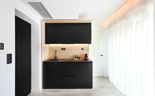 a kitchen with black cabinets and a sink at ICON Urban Living in Thessaloniki