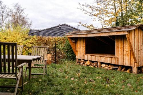a wooden dog house with a table and chairs at Cooking Over Fire And Coziness Near Ajstrup Beach in Ajstrup Strand