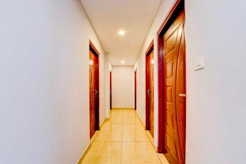 a hallway with wooden doors and a tile floor at Collection O Pukkattupady Aluva East in Kakkanad