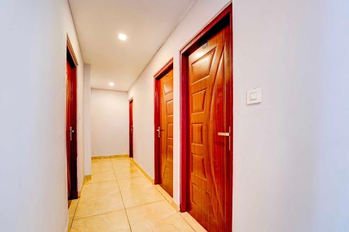 a hallway with two wooden doors and a tile floor at Collection O Pukkattupady Aluva East in Kakkanad