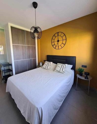 a bedroom with a large bed with a clock on the wall at Viva La Zenia in Orihuela Costa