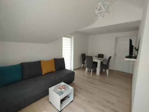 a living room with a couch and a table at Oaza apartman in Soko Banja