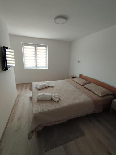 a bedroom with a bed with two towels on it at Oaza apartman in Soko Banja