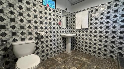 a bathroom with a toilet and a sink at Kurulu Kele Family Tree House in Sigiriya