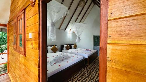 a room with two beds in a room at Kurulu Kele Family Tree House in Sigiriya