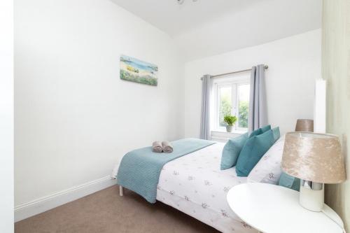 a white bedroom with a bed and a window at Calder Row by Alt-Stay Contractor Accommodation - 3 Bed Canal Side Contractor Home With Parking, Wi-Fi & Full Kitchen - Ideal For Long stays in Wakefield