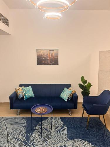a living room with a blue couch and a table at LA MAISON, Horizon Towers,AJMAN in Ajman