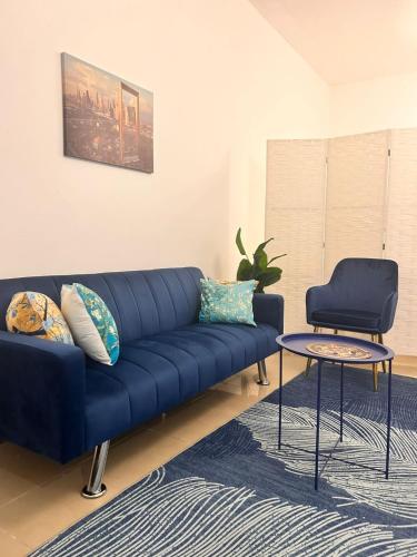 a blue couch in a living room with a table at LA MAISON, Horizon Towers,AJMAN in Ajman