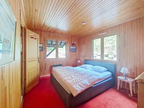 a bedroom with a bed in a room with wooden walls at CHALET AVORAZ AVR NATURE & VIEW 10 Pers in Châtel