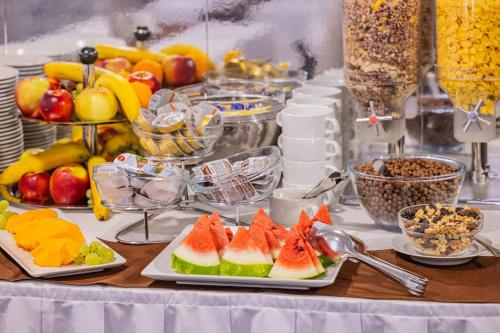 a buffet with fruits and other food on a table at Hotel Central in Nyíregyháza