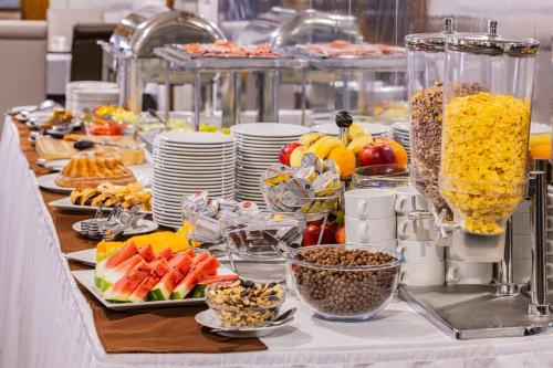 a buffet of food on a table with plates of food at Hotel Central in Nyíregyháza