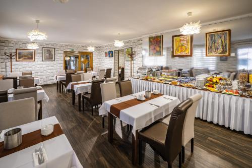 a dining room with tables and chairs and a buffet at Hotel Central in Nyíregyháza
