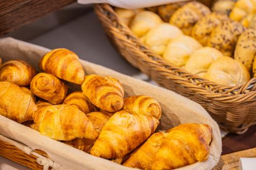a bunch of pastries in baskets on a table at Hotel Central in Nyíregyháza