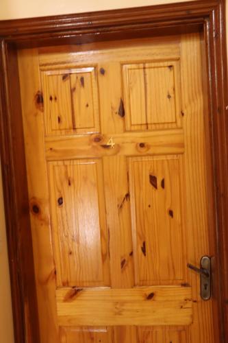 a wooden door with wooden panels on it at Londoninnn in Bijilo