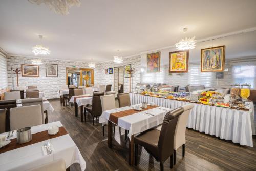 a restaurant with tables and chairs and a buffet at Hotel Central in Nyíregyháza
