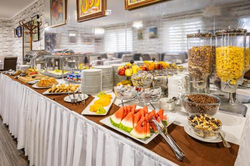 a buffet line with fruits and other food on plates at Hotel Central in Nyíregyháza