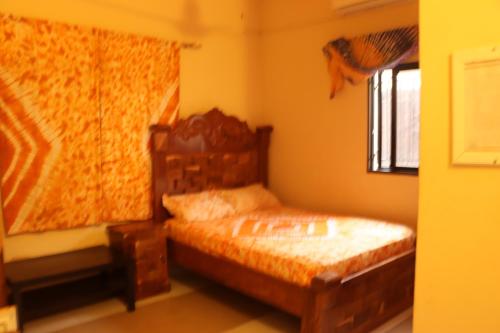 a bedroom with a bed and a window at Londoninnn in Bijilo