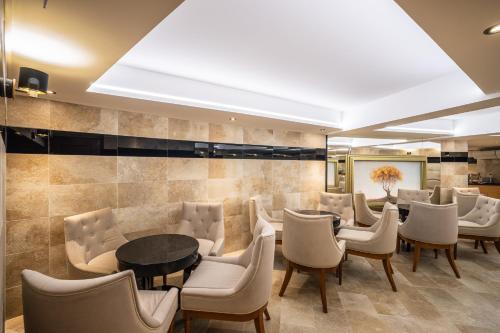 a dining room with chairs and a table and a wall at Hotel Central in Nyíregyháza