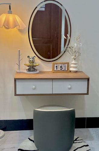 a bathroom with a mirror and a toilet with a clock at Lucasta Hotel in Can Tho