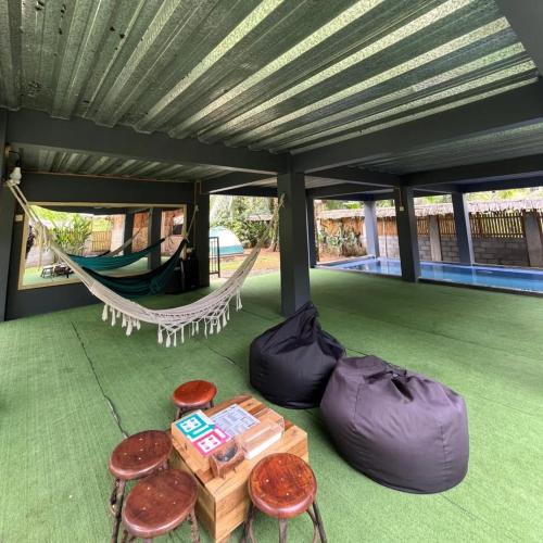 a porch with a hammock and a table and chairs at kalek villa in Bandarbuat