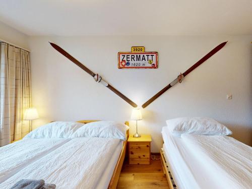 a bedroom with two beds and a sign on the wall at Beautiful apartment in Zermatt with a breathtaking view of the Matterhorn in Zermatt