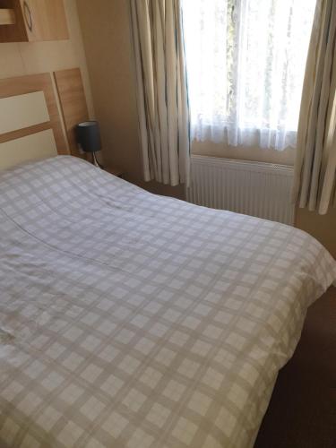 a bedroom with a bed with a checkered blanket at cleethorpes beach in Humberston