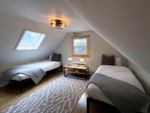 a attic bedroom with two beds and a table at Lake House, Fire Pit, Kayaks Magnolia Lake House in Ferndale