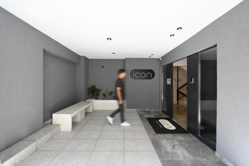 a man walking through a room with a sign on the wall at ICON Urban Living in Thessaloniki
