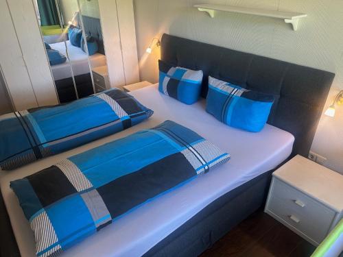 a bed in a room with blue pillows on it at Kurhotel Schluchsee Apartment 1305 in Schluchsee