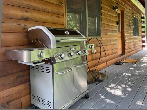 a grill on a porch next to a house at Red Tail Ridge in North Branch