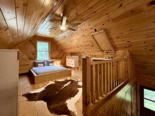 a log cabin bedroom with a bed and a ceiling fan at Red Tail Ridge in North Branch