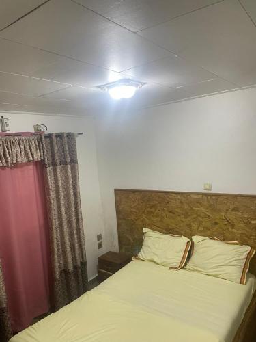 a bedroom with a bed and a red curtain at BML Host in Douala