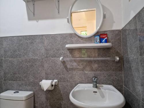 a bathroom with a sink and a mirror and a toilet at 3 Bedrooms 2 storey House in Dipolog