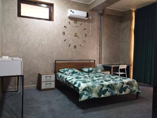 a bedroom with a bed and a clock on the wall at Nari Hotel in Tashkent