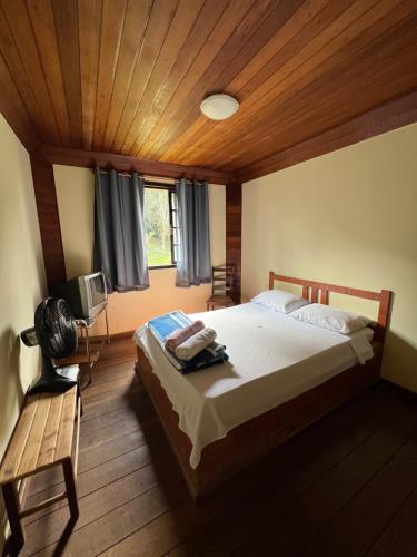 a bedroom with a large bed and a wooden ceiling at Hospedaria Tinoco in Ipiabas