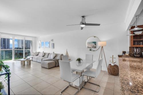 a living room with a couch and a table and chairs at Amazing 2Bed - Gym & Tennis Court -Ocean view in Sunny Isles Beach