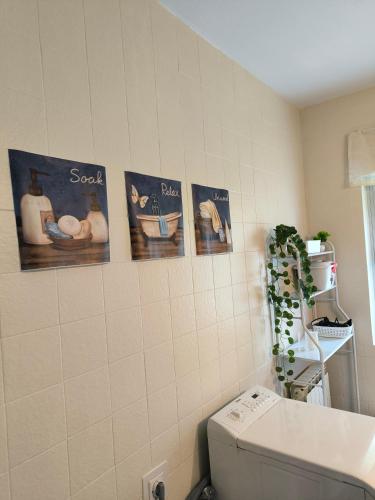 a bathroom with pictures of people on the wall at Casa las granxias in El Escobal