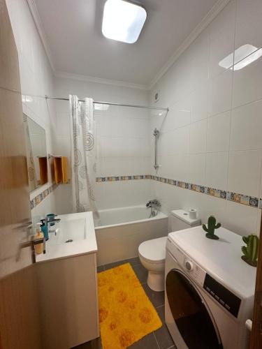 a bathroom with a sink and a toilet and a tub at Atlantic Foz in Buarcos