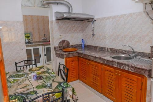 cocina con encimera, fregadero y mesa en Bab chaouen, en Chefchaouen