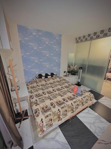 a bedroom with a bed with a patterned comforter at Stylish Bangkok Condo Furnished, Pool View Prime Location in Ban Nong Chaeng