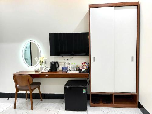 a desk with a computer and a mirror at Lucasta Hotel in Can Tho