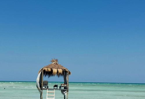 a chair with a straw umbrella on a beach at Villa Dar Rayan & Naelle in Midoun