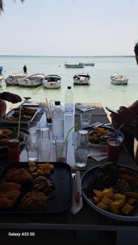 a table with a bunch of food on the beach at Villa Dar Rayan & Naelle in Midoun