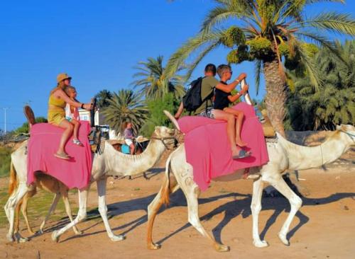 a group of people riding on the backs of camels at Villa Dar Rayan & Naelle in Midoun